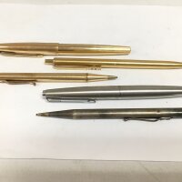 Two Parker pens, a silver propelling pencil and one other pen.