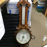 A carved oak barometer.
