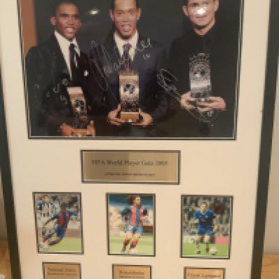 Ronaldinho Eto + Lampard Signed Football Display: Framed unglazed display with photo of the 2005 FIFA Presentation for the World Player of the Year. The event was held on the 19 December 2005 at the Zurich opera house. The winner was Ronaldinho. Signed by all 3 on main photo with photos underneath showing players in club kit.