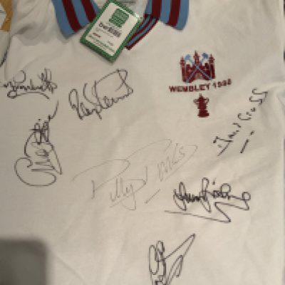 West Ham Football Memorabilia Box: Books, early Hammers News, programmes, programme inserts and a few 1966 World Cup items. C/W 1980 FA Cup replica shirt signed by 7 and a 1975 FA Cup final shirt signed by 3.