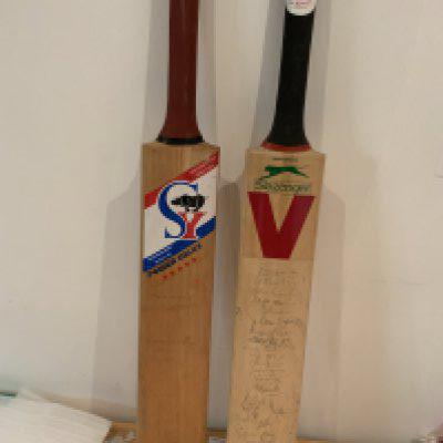 Cricket Memorabilia Box: 2 signed bats including England and India on one bat plus 1990 Pakistan which is fading. Cricket books, Annuals, Postcards, 1956 Autographs, Middlesex signed player postcards and more. Instructions to sell. (2 boxes)
