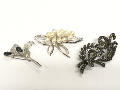 Three silver brooches of naturalistic form.