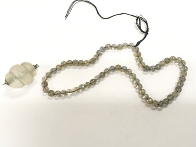A string of water opal beads and a crystal pendant.
