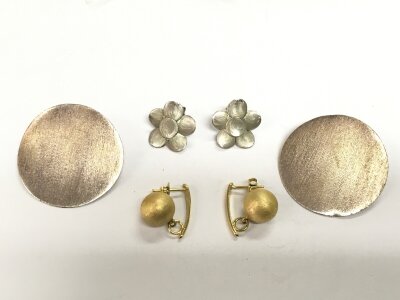 Three pairs of silver/white metal earrings.