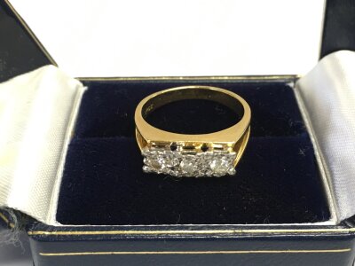 An 18ct gold three stone diamond ring, approx 4.9g and approx size L.
