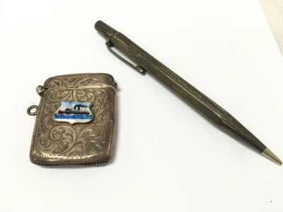 A silver vesta and a pen