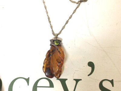 A large Baltic Amber pendent with white metal mount and chain and green stone cabochon.