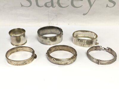 Five silver bangles and a silver napkin (6).