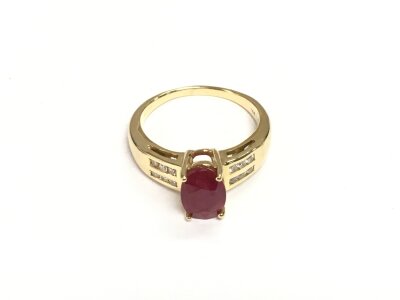 A 14k gold ring set with a central ruby with diamond chips to the shoulders, approx 4.5g and approx size O.