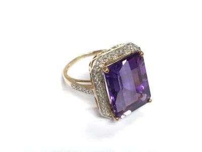 A 9k gold amethyst ring surrounded by diamond chips, approx 5.6g and approx size N.