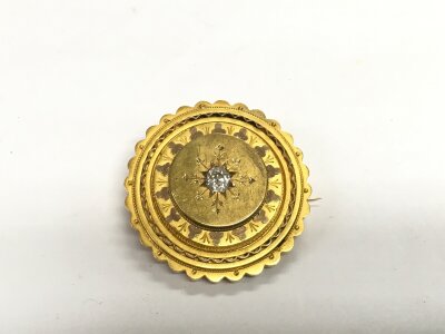 A Victorian gold brooch set with an old cut cushion solitaire diamond, approx width of brooch 3.5cm.