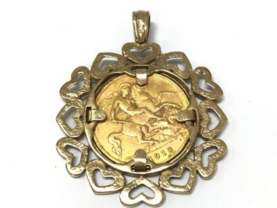 A George V half sovereign 1918 with a 9ct gold heart design coin mount. 8.5g