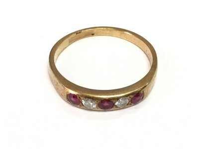 An unmarked yellow metal ring set with alternating rubies and diamonds, approx 2.3g and approx size P.