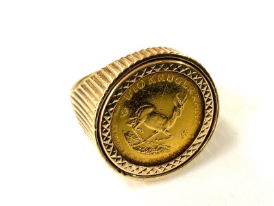A 1982 1 tenth ounce krugerrand, mounted in a 9ct gold signet ring mount.