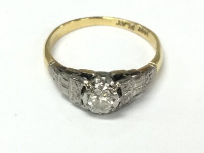 An 18ct gold and platinum ring set with small central diamond. Size M and 2.47g