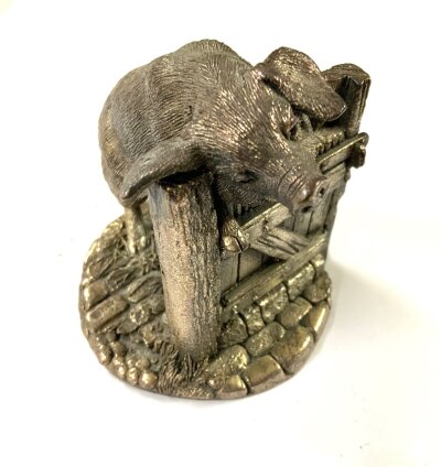 A hallmarked silver and resin filled figure of a pig resting on a gate. 7.5cm