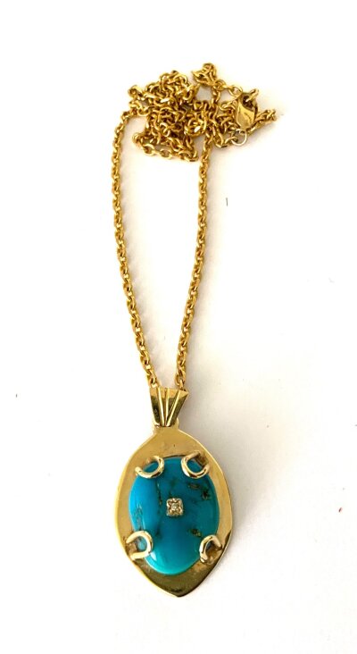 A custom made 9ct gold and raw turquoise pendant and chain with a 9ct gold chain.