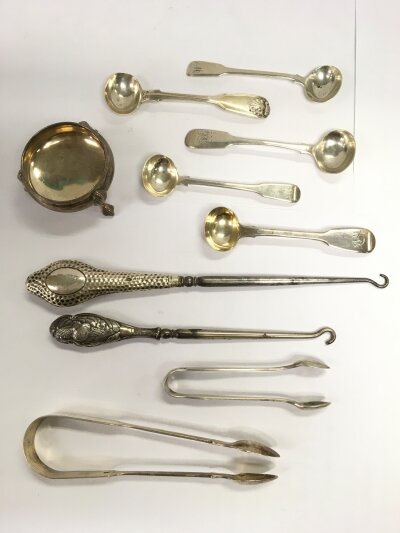 A small collection of silver items comprising spoons, sugar tongs etc,