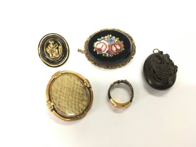 A yellow metal mourning brooch, ring and three other brooches.