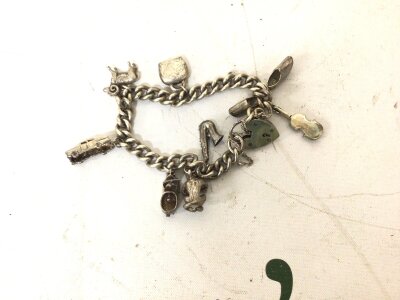 A Silver charm bracelet with attached charms.