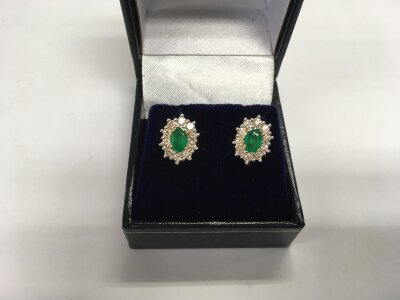 A pair of 9ct yellow and white gold oval emerald and RBC diamond cluster studs. Emeralds approx 1.01ct and diamonds approx 1.00ct. Approx 3.3g.