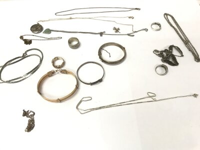 A collection of silver and white metal jewellery items including bangles and chains etc.