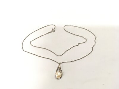 A silver tear drop pendant set with a cultured pearl and white cubic zirconia and suspended on a silver chain.