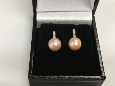A pair of 9ct white gold droplet earrings set with pale pink cultured pearls with diamond set bales, diamonds approx 0.05ct. Approx