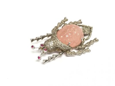 A large silver brooch and pendant in the form of a beetle set with a central oval carved morganite, rubies and diamonds. Morganite approx 26.39ct, Rubies approx 0.15ct and diamonds approx 1.81ct.
