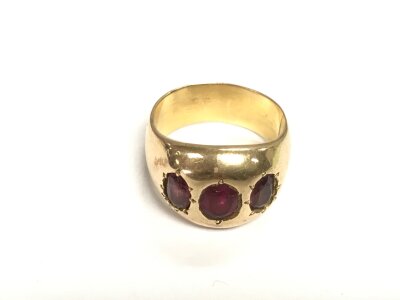 An unmarked gold ring set with three garnets, approx 15.8g and approx size T-U.