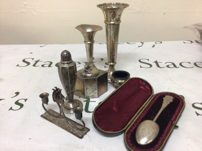 A Collection of silver comprising loaded silver vases a cased silver spoon a silver mounted table lighter small silver candle holder and other ornaments