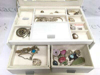 A jewellery box containg various silver jewellery items.