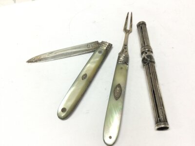 A silver penknife , fork and pen