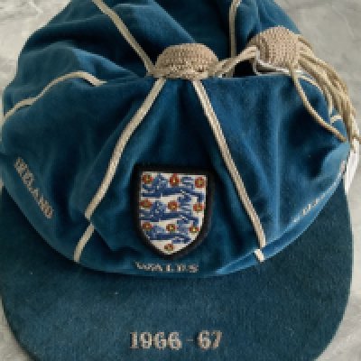 Nobby Stiles England International Football Cap: Blue full international cap with three lions to front and the words Ireland Wales and Scotland which refer to the home championship matches the Manchester United star played in. The peak reads 1966-67 and England entered the tournament as World Cup winners. Sold originally in 2010 lot 117 at Convery Auctions where Nobby sold his collection. Excellent condition.