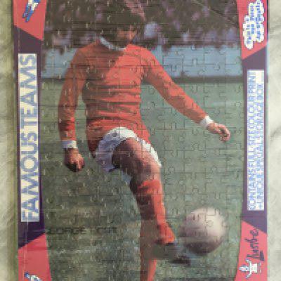 George Best Manchester United Jigsaw Puzzle: Still sealed and in packaging featuring Best in Manchester United kit made in the 70s by Lustre. 250 pieces. Rare poster to rear as guide for making up.