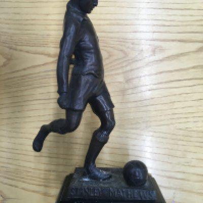 Stanley Matthews Bronze Football Statue: Heavy bronze statue measuring nearly 10 inches high with the name Stanley Mathews to base. C/W port Vale December 2006 Player of the Month ceramic tankard awarded to Leon Constantine made by Wade. Not for posting. (2)