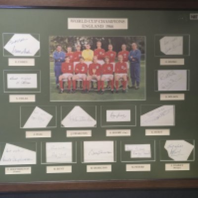 1966 England World Cup Fully Signed Framed Display: Large famous colour photo of the 11 players who won the World Cup with Ramsey and Shepherdson. Separately mounted is a genuine autograph of all 13 removed from exercise book. Large item not for posting.