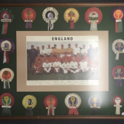 1966 World Cup Complete Rosette Collection: Very heavy and large framed display with an original rosette of every one of the participating 16 teams. In the middle is a poster of the England squad. Stunning item.