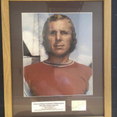 Bobby Moore West Ham Signed Framed Picture: Very large picture of Moore in West Ham kit with his autograph on white paper underneath with his West Ham stats.