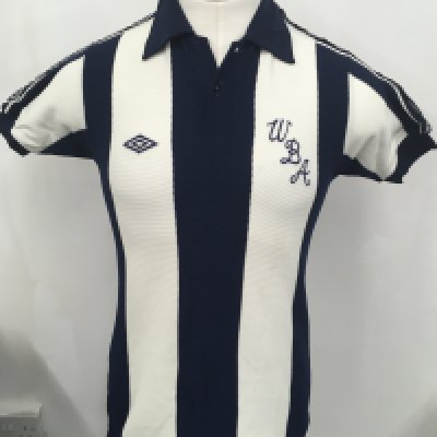 West Brom 1970s Match Worn Home Football Shirt: Short sleeve with number 4 to rear which has some cracking. Worn by Tony Brown. John Kaye his friend and team mate has signed inside rear at the base near hem. Good condition with no top button and Umbro shoulder badging is a bit loose.
