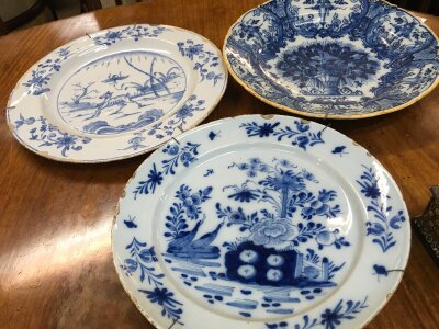 Three 18th century Delft wall plaques and one Victorian blue and white dish (some damage). 32cm wide