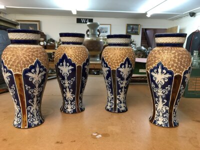 Four Royal Doulton Lambeth stoneware vases, decorated with stylised foliage. Some A/F. All 28cm in height