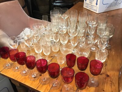 A collection of cranberry glass and other glass
