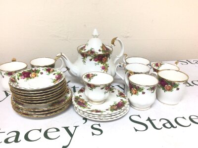 A Collection of Royal Albert old English Country Rose bone china comprising a tea pot coffee cups tea cups side plates and saucers gilding rubbed on some saucer edges.