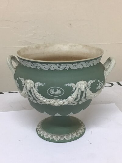 A 19th century Wedgwood green jasper ware urn with neo classical decoration impressed marks Wedgwood to the base the interior with stains Hight 15cm and two 20th century ash trays (3)
