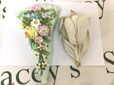 A quality porcelain wall pocket with raised flowers and foliage and one other porcelain wall pocket extremely minor chip to flower petal otherwise no damage  (2)