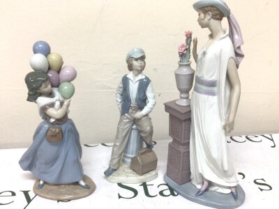 Two Lladro figures a young girl with balloons and a classical lady standing by a pillar with flowers 34 cm high and a NAO shoe shine boy all with boxes and no obvious damage. (3)