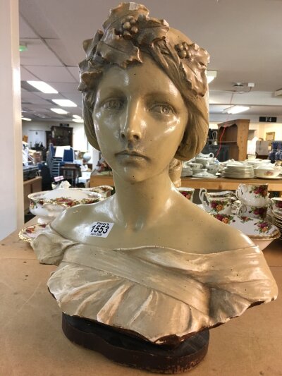 A plaster bust of a maiden wearing holly and berries in her hair. Some damage.  40cm in height, on a wooden base