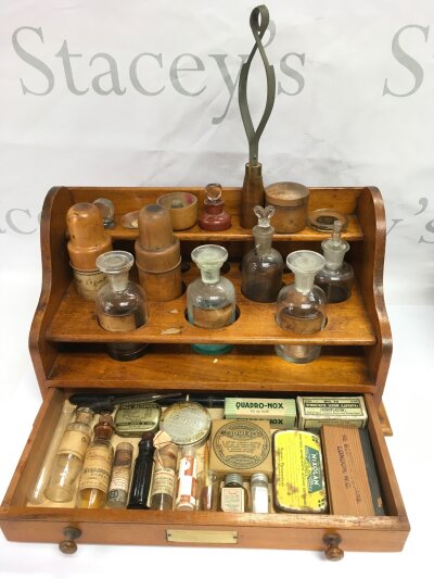 A cased apothecary set with various glass bottles and phials.