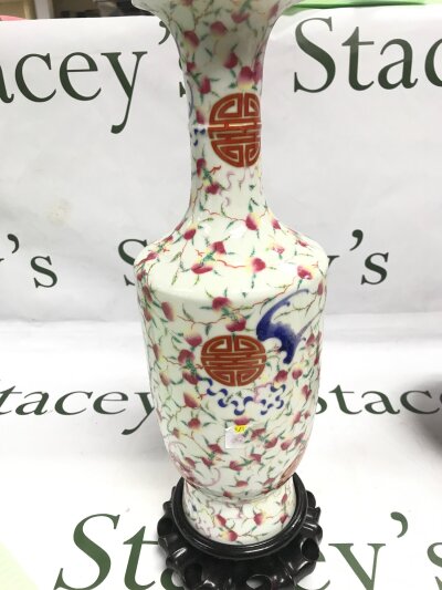 A Chinese famille rose bats and peaches vase, 31cm tall. Six character mark at base. With wooden base.